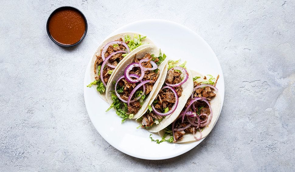 picture of tacos on plate with a side of sauce